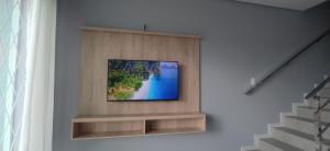 a television on a shelf in a wall at Sobrado em Piçarras com piscina in Piçarras