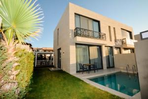 a house with a backyard with a swimming pool at Blue Point Hotel Yalikavak in Yalıkavak