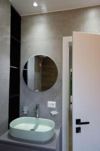 uma casa de banho com um lavatório e um espelho em Cozy Apartments em Tirana