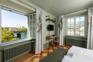 a bedroom with a bed and a large window at Hotel an der Aare Swiss Quality in Solothurn
