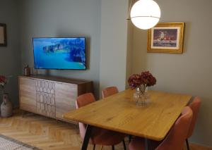 a dining room with a wooden table and a television at Absolute Athens Acropolis View in Athens