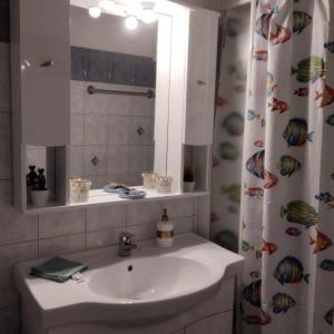 y baño con lavabo y espejo. en Small and cosy appartment- Piccolina, en Loutraki