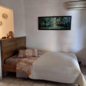 a bedroom with a bed and a painting on the wall at Small and cosy appartment- Piccolina in Loutraki
