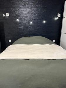 a bedroom with a bed with a black wall at Maison de charme - Cœur de Brest in Brest