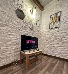 a living room with a tv on a white wall at Maison de charme - Cœur de Brest in Brest