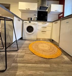 a kitchen with a washing machine and a rug on the floor at Maison de charme - Cœur de Brest in Brest