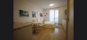 a room with two beds and a table and a window at Студио Сарафово in Burgas City +5 photos