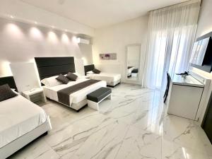 una camera con due letti e un ampio pavimento in marmo di Hotel Blu a Porto Cesareo