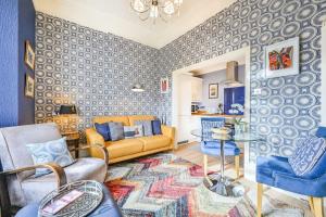 - un salon avec un canapé jaune et des murs bleus dans l'établissement Große Wohnung in Torquay mit Terrasse, Grill und Garten, à Torquay