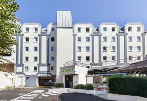 um grande edifício branco com uma rua em frente em B&B HOTEL Rouen Centre Rive Droite em Rouen
