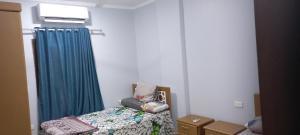 a bedroom with a bed and a blue curtain at Ikea flat 10 in Hurghada