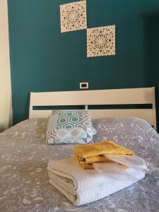 Una cama con toallas y una almohada. en Borgo Fiore House, en Parma