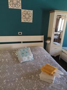 1 dormitorio con 1 cama con toallas y espejo en Borgo Fiore House, en Parma