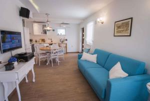 a living room with a blue couch and a kitchen at Holiday home Privlaka/Zadar Riviera 8218 in Batalaži