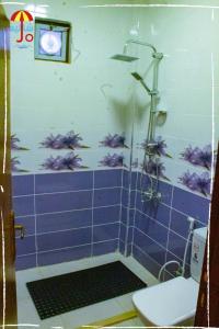 ein blau gefliestes Bad mit einer Dusche und einem WC in der Unterkunft Royal eagle in Al Rama