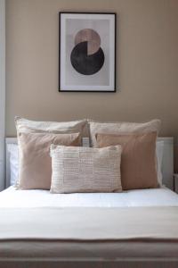 Una cama con sábanas blancas y almohadas en un dormitorio en The St John's Wood Apartment en Londres