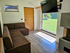 a living room with a couch and a flat screen tv at Big Windows, Endless Views by Pintar Apartments in Bohinjska Bela