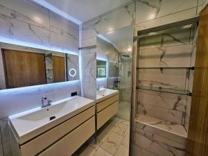a bathroom with two sinks and a glass shower at Big Windows, Endless Views by Pintar Apartments in Bohinjska Bela +16 photos