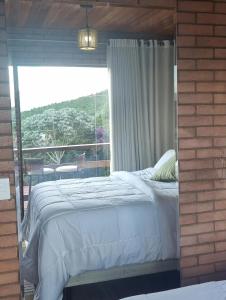1 dormitorio con cama y ventana grande en Vivendas Canaã, en Espera Feliz