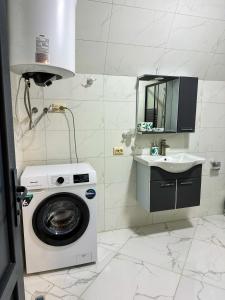 een badkamer met een wasmachine en een wastafel bij Martvili canyon cottage in Gachedili