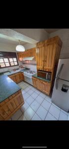eine große Küche mit Holzschränken und einem Kühlschrank in der Unterkunft Hotel RJ Querétaro in Querétaro
