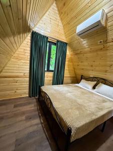 a bedroom with a bed in a wooden room at Martvili canyon cottage in Gachedili