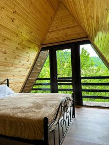 a bedroom with a bed in a room with windows at Martvili canyon cottage in Gachedili