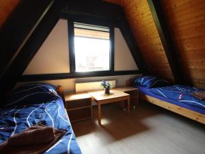 Zimmer mit 2 Betten, einem Tisch und einem Fenster in der Unterkunft Holiday home Amalie, Burhave in Burhave