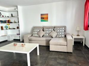sala de estar con sofá y mesa en Famara Sunshine, en Famara