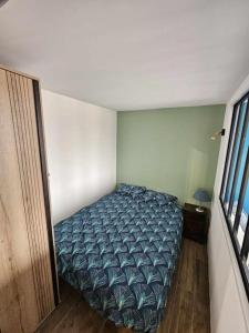 ein Schlafzimmer mit einem Bett in der Zimmerecke in der Unterkunft Appartement vue mer et dunes in Dunkerque