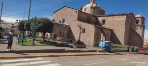 a man walking down a street in front of a building at ANDENES DEL TITICACA in Puno