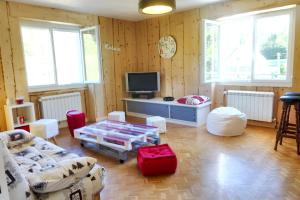 ein Wohnzimmer mit einem Sofa und einem TV in der Unterkunft Maison de 2 chambres avec jardin clos et wifi a Hauts de Bienne in Lézat