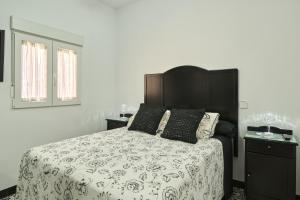 a bedroom with a bed with a black and white bedspread at Marisol' House in Puente-Genil +23 photos