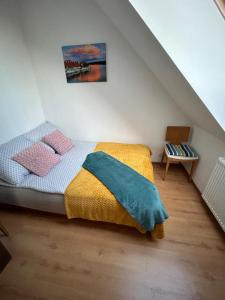a bedroom with a bed with a yellow and blue blanket at Apartament Róża in Giżycko