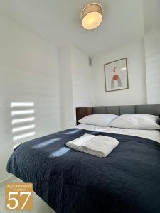 a bedroom with a bed with two towels on it at Piękny przytulny apartament - blisko akwenu wodnego in Radom