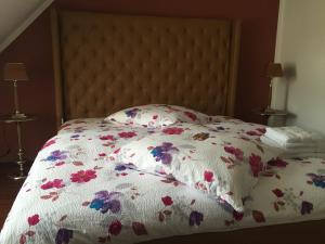 ein Bett mit einer weißen Bettdecke mit Blumen darauf in der Unterkunft Elbsandstein Apartments in Meißen