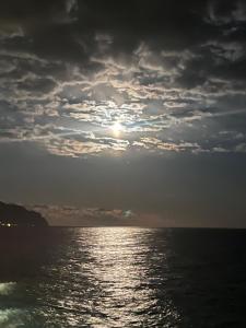 einen Sonnenuntergang über dem Meer mit wolkigem Himmel in der Unterkunft Il Conte di Caprafico in Genua