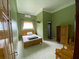 a room with green walls with a bench and a window at nhà nghỉ Ngọc Lam in Quang Ba