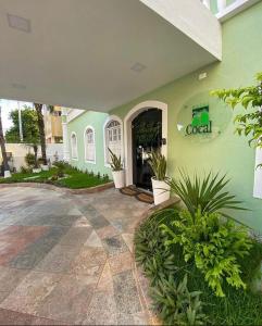 een groen gebouw met een bord aan de zijkant bij Hotel Cocal in Fortaleza