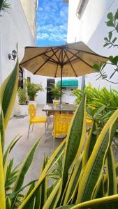 a patio with a table and chairs and an umbrella at Hotel Cocal in Fortaleza