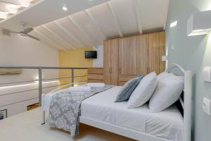1 dormitorio con 1 cama con sábanas blancas y almohadas azules en Viatzo Loft Apartment en Potamós