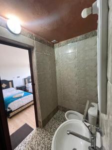 a bathroom with a sink and a toilet and a bed at Merzouga Lodge in Merzouga +36 photos
