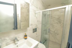 een badkamer met een douche, een wastafel en een spiegel bij Sulty's Alaçatı in Izmir