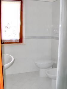 uma casa de banho branca com um WC e um lavatório em 3 bedrooms house at Lacona 100 m away from the beach with enclosed garden em Lacona