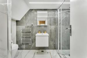 a bathroom with a shower and a sink and a toilet at Cleveland Residences Chelsea in London