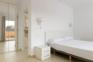 a white bedroom with a bed and a mirror at Seraph by ON Travel in Oliva +9 photos