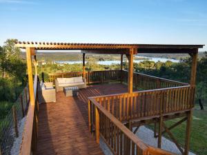 una terraza de madera con cenador y sofá en Caju Villas Montargil - Villa Farinha Branca, en Montargil