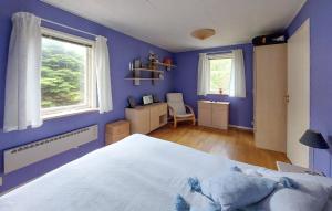 Dormitorio azul con cama y escritorio en 4 Bedroom Nice Home In Örkeljunga, en Orkelljunga