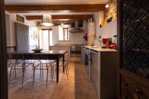 eine Küche mit einem Tisch und einigen Stühlen in der Unterkunft La dimora degli artisti in Torre Alfina