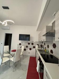 a kitchen with white chairs and a table and a red rug at Tiburtina Flats in Rome